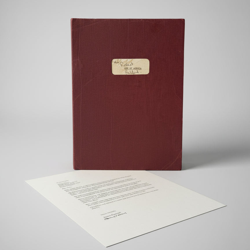 Red book with a white page showing text on a marble surface